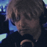 a close up of a man wearing headphones and a microphone with the letter o on it