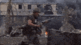 a soldier is holding a gun in front of a building with smoke coming out of it