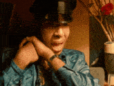a man wearing a hat and a watch is making a face