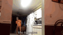 a boy in an orange shirt is dancing in a kitchen with the words who do you love below him