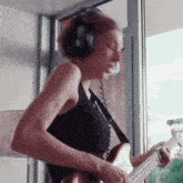 a woman wearing headphones is playing a guitar with the website p3ns1v3.tumblr.com in the corner