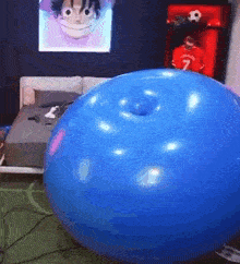 a large blue balloon with a hole in the middle is sitting in a bedroom .