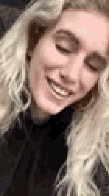 a close up of a woman 's face with her eyes closed smiling .