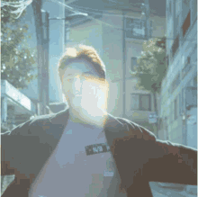 a man wearing a purple shirt and a black jacket is walking down a street with his arms outstretched .
