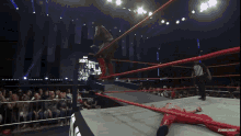 a wrestler is laying on the ground in a wrestling ring with the words impact plus on the mat