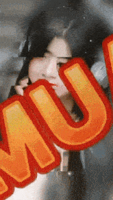 a close up of a woman behind a sign that says mu