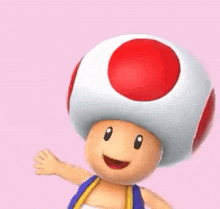 a toad with a red circle on his head is standing on a pink background and smiling .