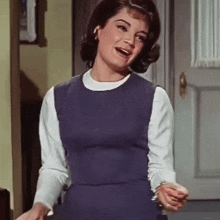 a woman in a purple dress and white shirt is laughing
