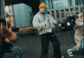a man in a yellow hat is dancing on a street