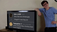 a man leans against a large flat screen tv that says echo wmp whos that one chinese guy