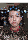 a man wearing a leopard print shirt is making a face with blue stars on his face