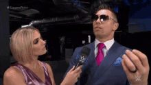 a man in a suit and tie is being interviewed by a woman with a microphone and the words extreme rules on the bottom