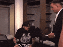 a man wearing a t-shirt that says gis is talking to another man