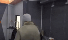 a person is standing in a room with a hanger on the wall .