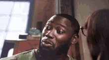 a man with a beard is looking at a woman .