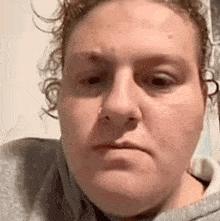 a close up of a woman 's face with a nose ring on it .