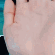 a close up of a man in a suit and tie making a funny face with his hand .