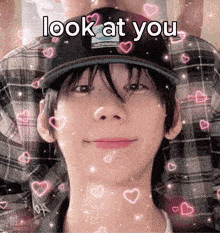 a young man wearing a hat with the words look at you surrounded by hearts