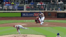 a baseball game is being played in front of a mlb.com sign