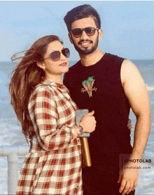 a man and a woman are posing for a picture and the man is wearing a shirt that says tropical delight