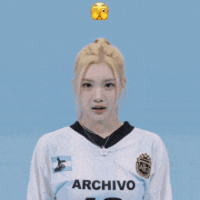 a woman wearing a white archivo shirt is making a funny face