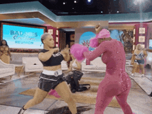 two women are boxing in front of a screen that says baddies