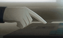 a hand is pressing a button on a laptop screen