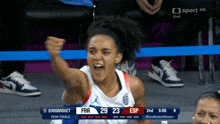 a female basketball player celebrates a score of 29 to 23 against esp