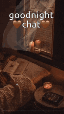 a bed with a book and candles in front of a window with the words goodnight chat written on it .