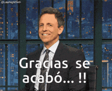 a man in a suit and tie is smiling and holding a megaphone that says gracias se acabo