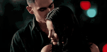a man is holding a woman 's neck and she is smiling