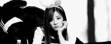 a black and white photo of a woman wearing bunny ears and a headband .