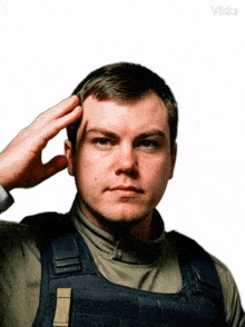 a man salutes in front of a white background with the word vida on it