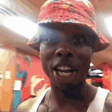 a woman wearing a red hat and white tank top smiles