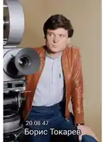 a man is sitting in front of a camera with the date 20.08.47 on the bottom