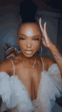 a woman with a bun on her head is wearing a very revealing white dress