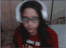a young girl wearing headphones and a red shirt that says want to