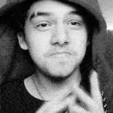 a black and white photo of a young man wearing a hoodie