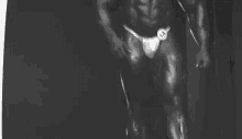 a black and white photo of a bodybuilder wearing a number 14 .