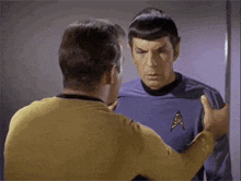 two men standing next to each other with one wearing a star trek uniform