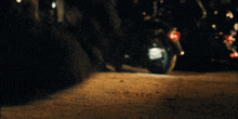 a motorcycle is parked on a dirt road in the dark