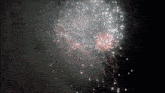 a fireworks display in the night sky with white and red fireworks