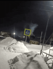a crosswalk sign in the snow at night with smoke coming out of it