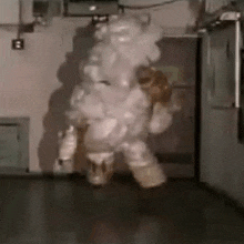 a person in a space suit is standing in a room with a lot of smoke coming out of their mouth .