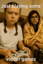 two girls are sitting on a couch playing video games with the caption just playing some vider games