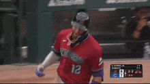 a baseball player in a red jersey with the number 12 on it