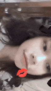 a close up of a woman 's face with a red kiss on her lip