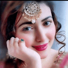 a woman wearing a headpiece and a ring is smiling .