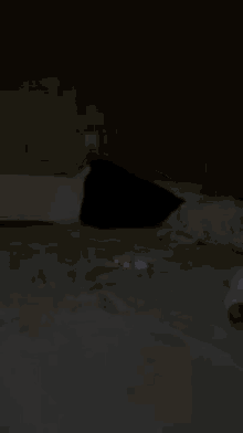 a person is laying on a bed in the dark with a red light coming out of the corner .
