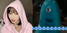 a girl in a pink hoodie is sitting next to a blue monster with one eye .